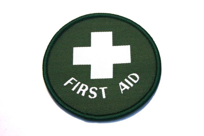 Tygmärke första hjälpen - FIRST AID